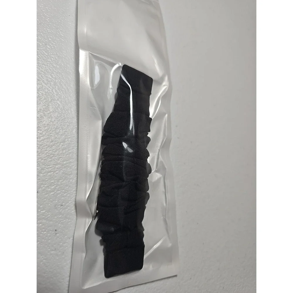 Scrunchie-style watch band for a fitness tracker, made of a black, ruched fabric